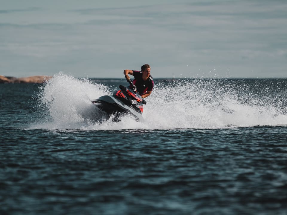 Vozač na jet skiju u oštrom zavoju podiže val